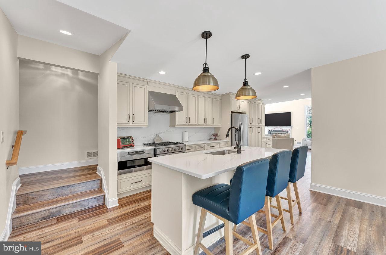 20 Wolfpack Road Hamilton, NJ 08619 - Photo 4 of 25 a kitchen with stainless steel appliances kitchen island granite countertop a sink a stove and a wooden floors