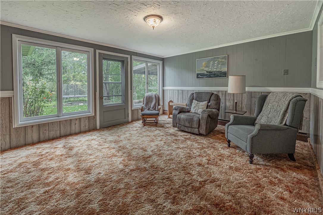 6775 Bear Ridge Road Pendleton, NY 14094 - Photo 29 of 48 Wood paneling and abundant natural light create a classic, inviting atmosphere in this cozy space.