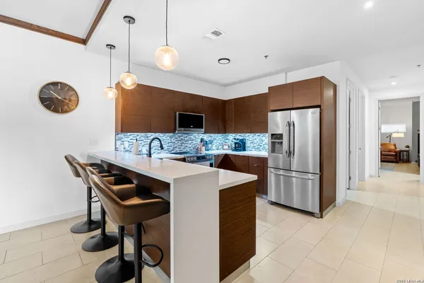 a kitchen with stainless steel appliances kitchen island granite countertop a refrigerator a stove a sink and a dining table with the view