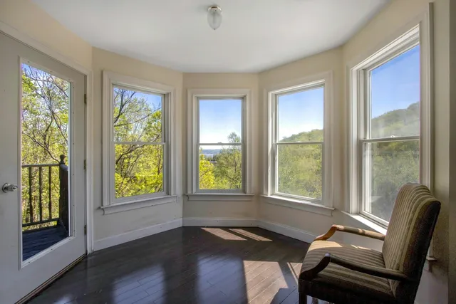 a view of a livingroom with lounge chair and a large window