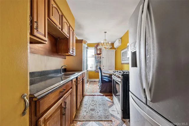 a kitchen with stainless steel appliances granite countertop a refrigerator a stove and a sink