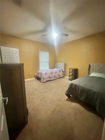 a spacious bedroom with a bed and a chandelier