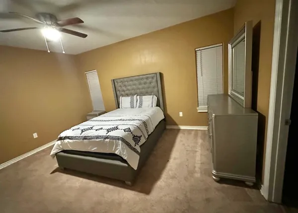 a spacious bedroom with a bed and a chandelier