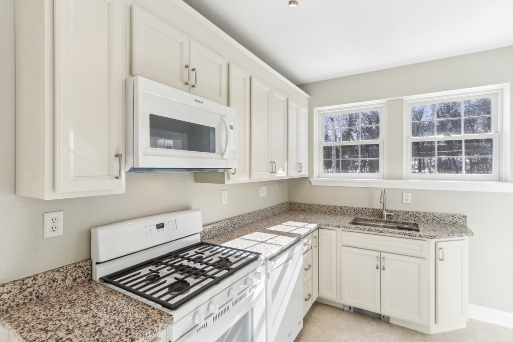 27 Elm Road, Unit D Devens, MA 01434 - Photo 10 of 31 a kitchen with granite countertop a stove sink and cabinets