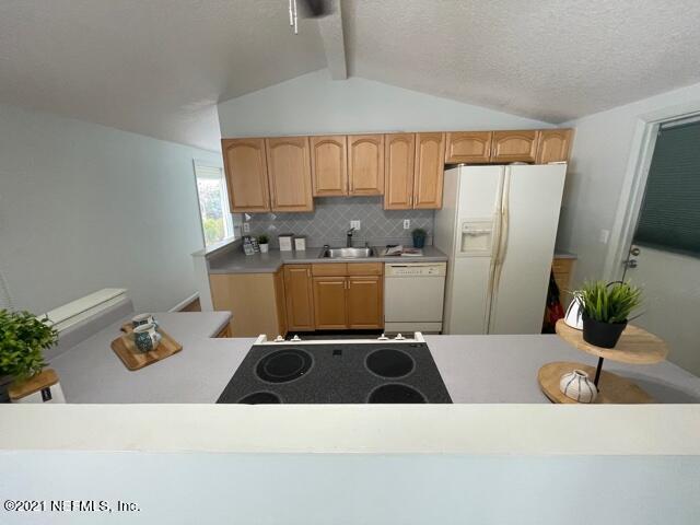 7124 St Augustine Road Jacksonville, FL 32217 - Photo 15 of 20 a kitchen with a refrigerator a stove a sink and a potted plant