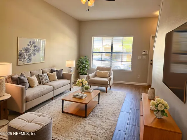 a living room with furniture wooden floor and a window