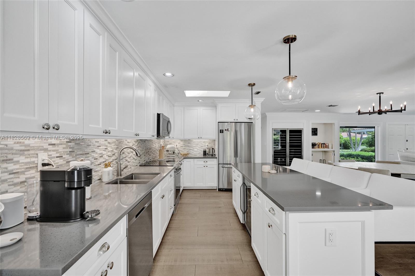 5854 Pinebrook Drive Boca Raton, FL 33433 - Photo 16 of 76 a large kitchen with stainless steel appliances kitchen island granite countertop a sink and a refrigerator
