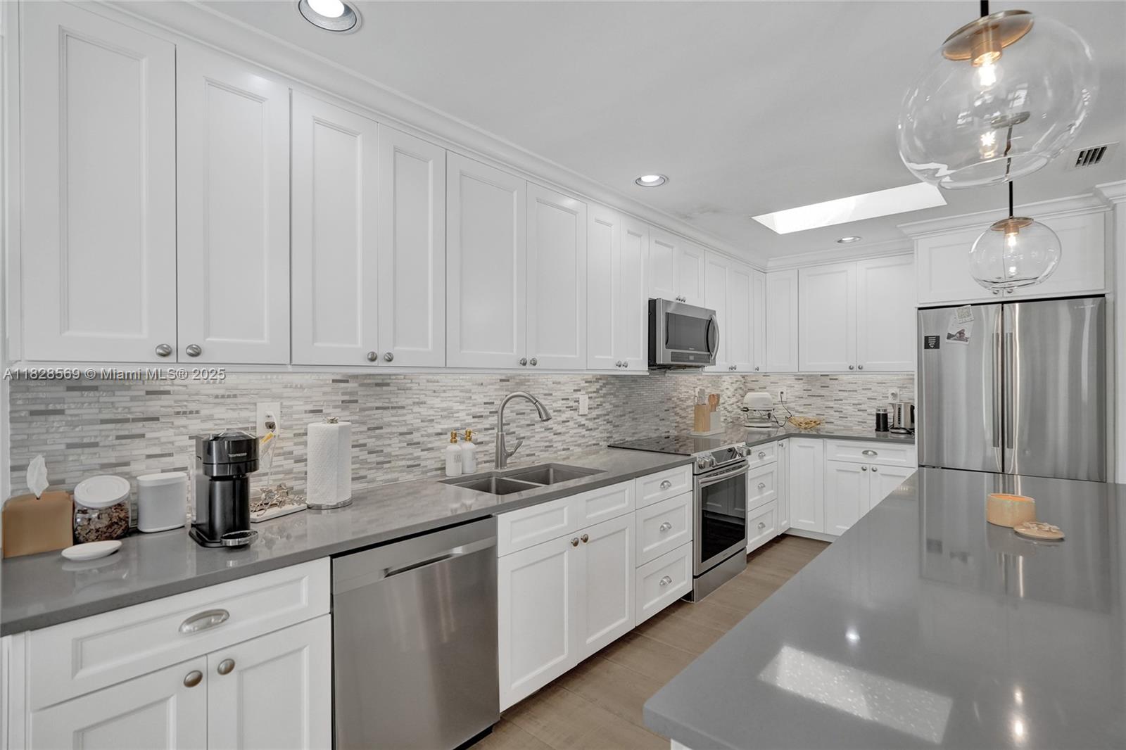 5854 Pinebrook Drive Boca Raton, FL 33433 - Photo 18 of 76 a kitchen that has a lot of white cabinets and stainless steel appliances
