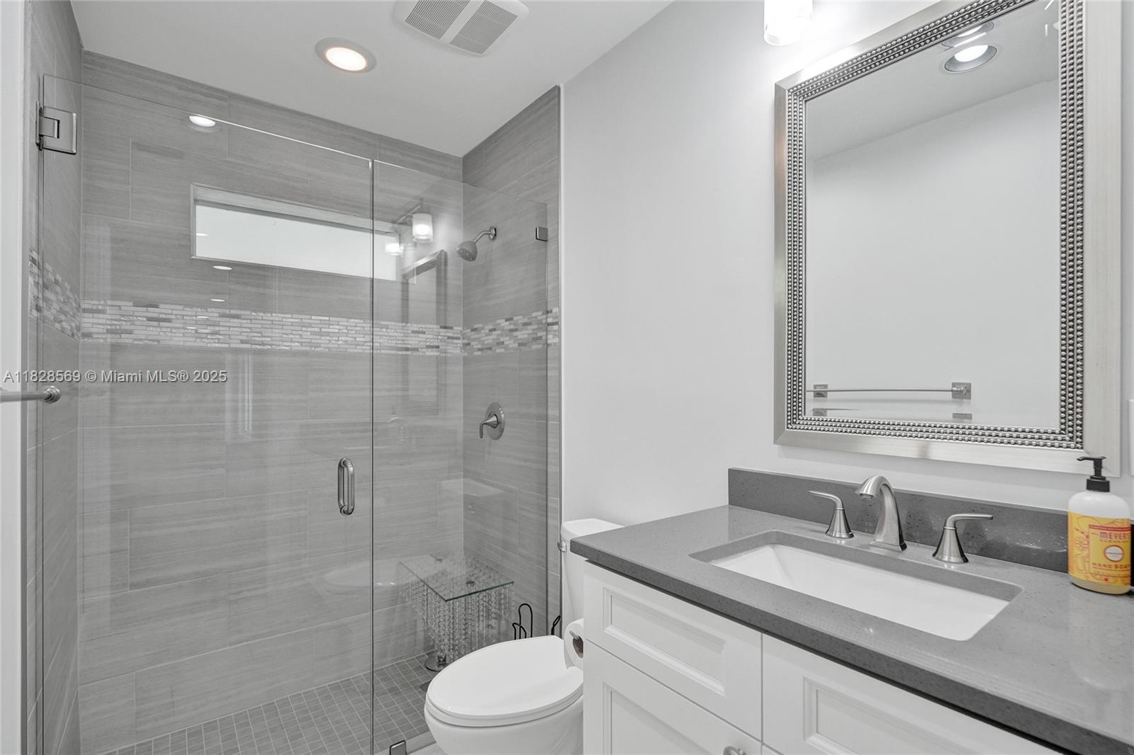 5854 Pinebrook Drive Boca Raton, FL 33433 - Photo 41 of 76 a bathroom with a granite countertop sink toilet a mirror and shower