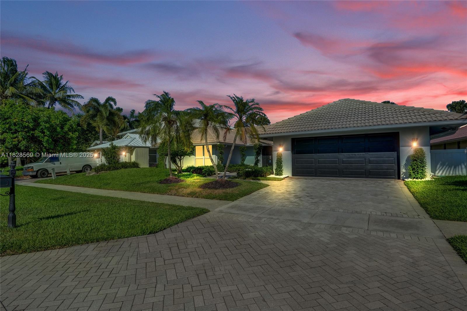 5854 Pinebrook Drive Boca Raton, FL 33433 - Photo 62 of 76 a front view of a house with a yard and a garage