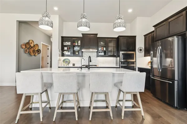 a kitchen with stainless steel appliances granite countertop a dining table and chairs