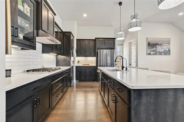 a kitchen with stainless steel appliances a sink stove and refrigerator
