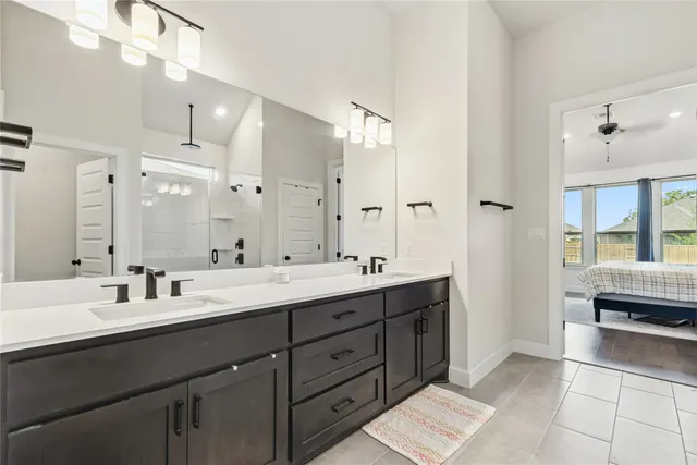 a spacious bathroom with a double vanity sink a mirror and a shower
