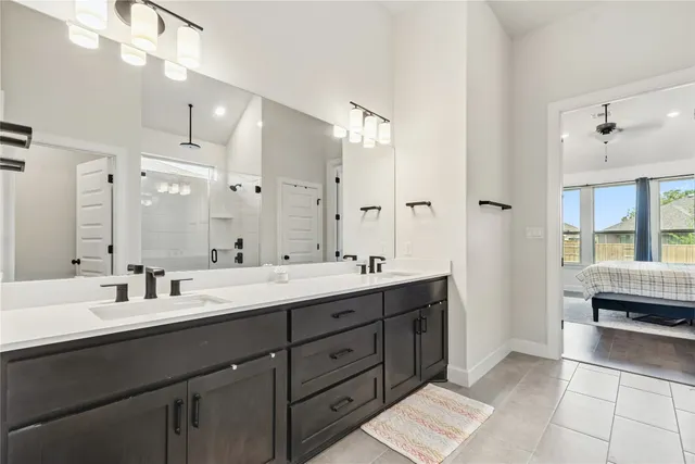 a spacious bathroom with a double vanity sink a mirror and a shower