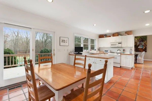 a kitchen with a dining table chairs and white appliances