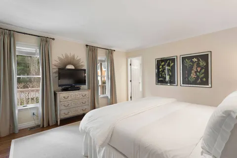 a bedroom with a large bed and a flat tv screen