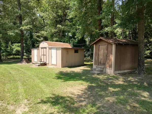 a front view of a house with a yard and trees
