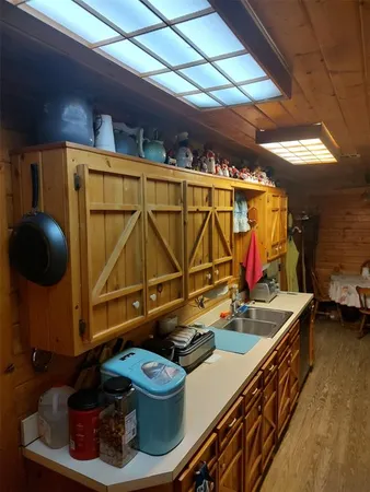 a utility room with stainless steel appliances kitchen island granite countertop lots of clutter
