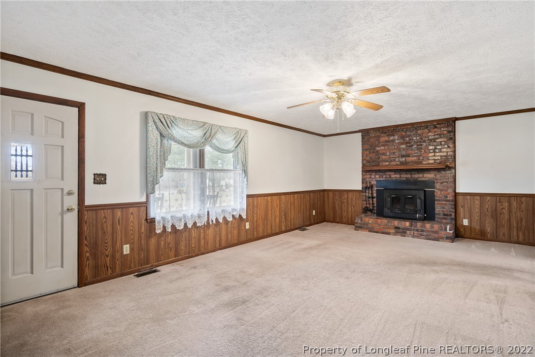 7876 Maxwell Road Stedman, NC 28391 - Photo 6 of 50 an empty room with windows and fireplace
