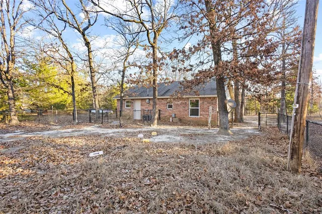 a backyard of a house with large trees and outdoor