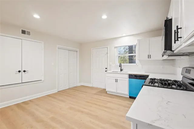 a kitchen with stainless steel appliances granite countertop a sink stove and cabinets