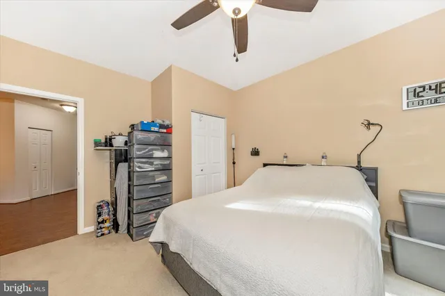 a bedroom with a bed and a ceiling fan