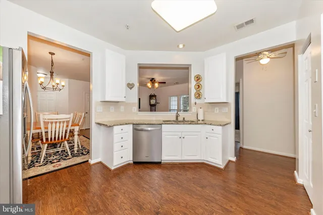 a large kitchen with granite countertop a sink and a wooden floor