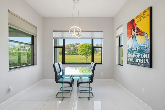 a view of a dining room with furniture a chandelier and window
