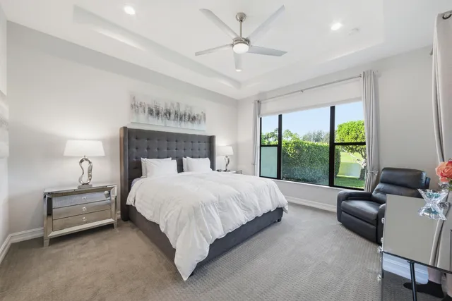 a bedroom with a bed couch and a large window