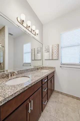 a bathroom with a granite countertop sink and a mirror