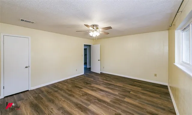 a view of a room with a ceiling fan and a window