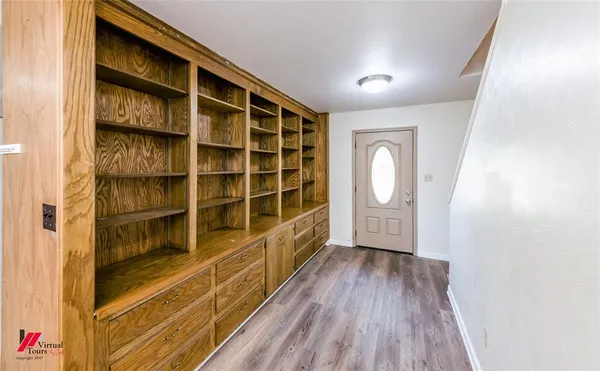 a view of empty room with wooden floor and cabinet