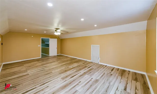 a view of an empty room with wooden floor