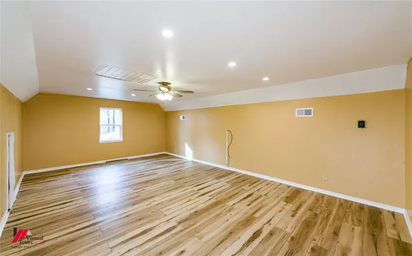 a view of empty room with wooden floor