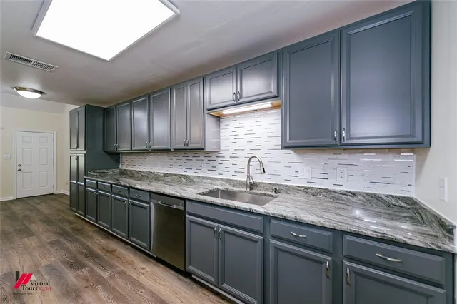 a kitchen with stainless steel appliances granite countertop a sink stove and cabinets