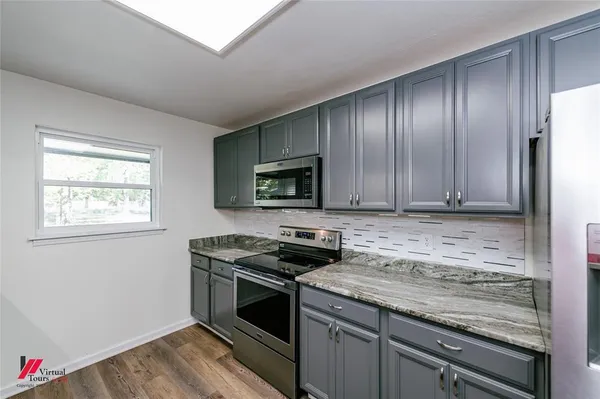 a kitchen with granite countertop wooden cabinets and stainless steel appliances