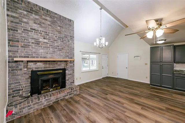 wooden floor fireplace and windows in an empty room