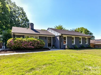 a front view of a house with a garden and yard