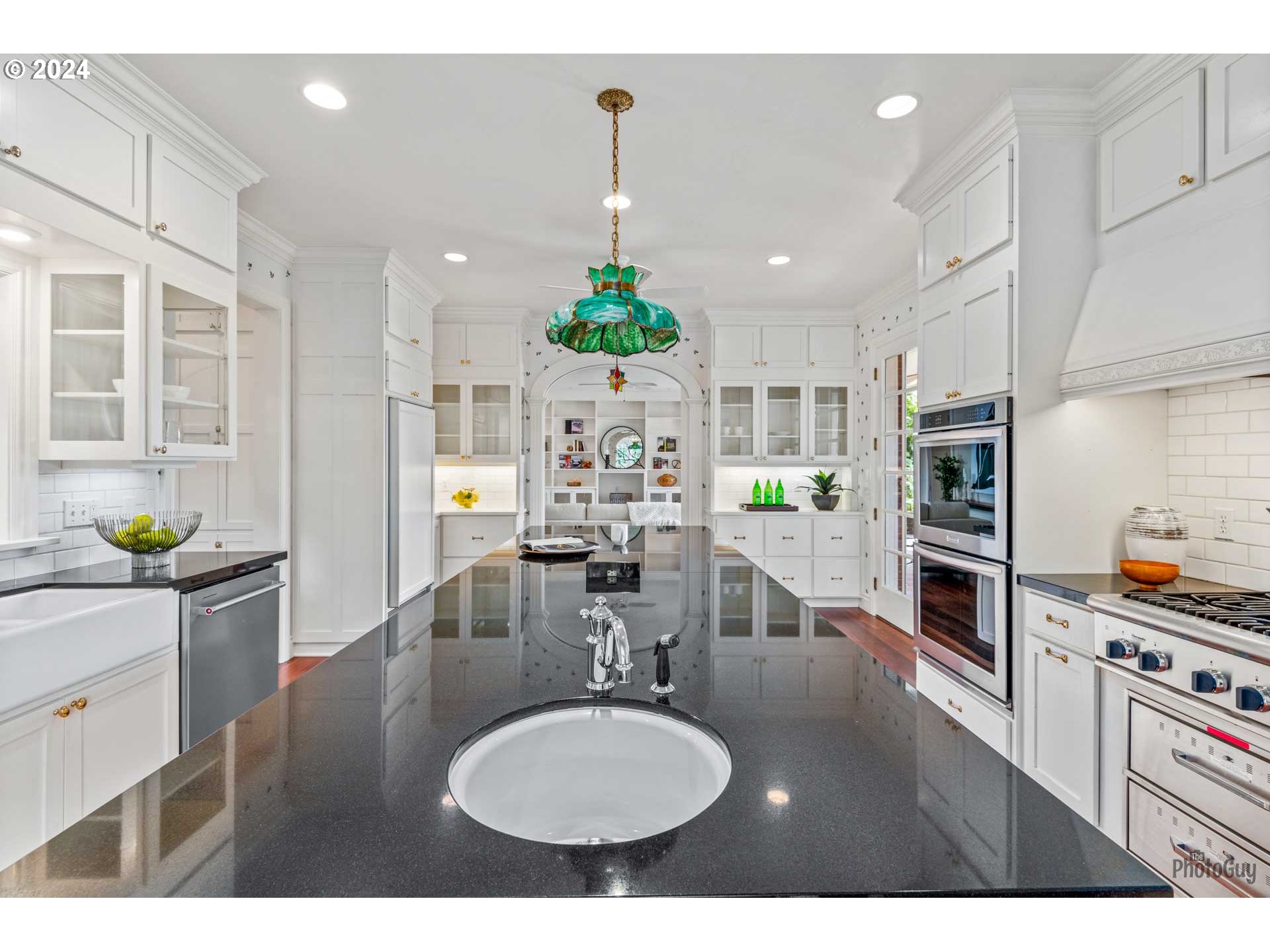 2788 Riverwalk Loop Eugene, OR 97401 - Photo 13 of 48 a kitchen with kitchen island granite countertop a sink cabinets and wooden floor