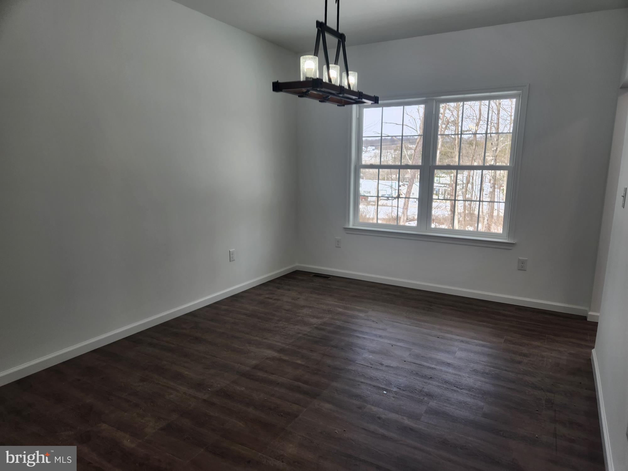 1929 Dunkleberger Road Elliottsburg, PA 17024 - Photo 11 of 48 an empty room with wooden floor chandelier and windows
