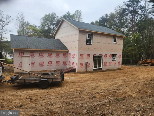 a view of a house with backyard and a car parked in it