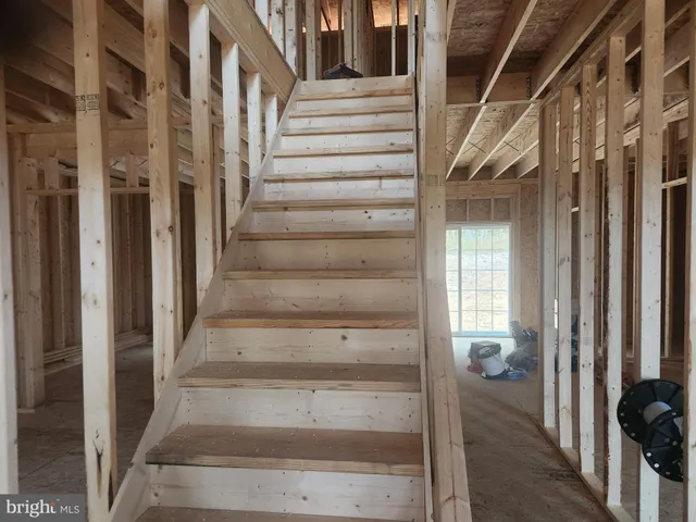a view of staircase with lots of frames on wall and a window