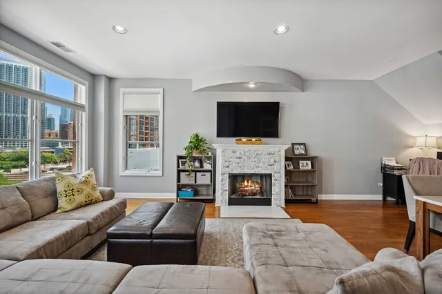 a living room with furniture a fireplace and a flat screen tv