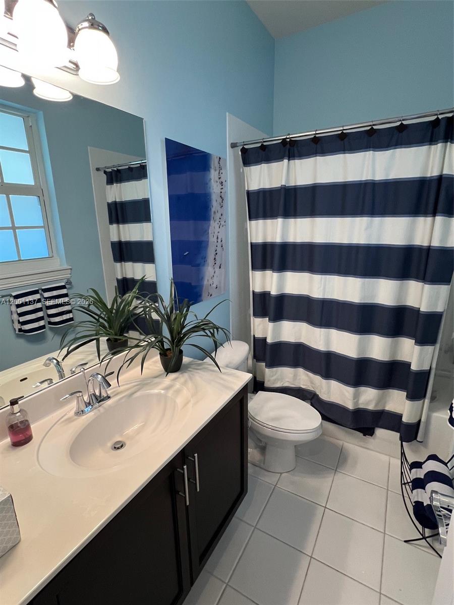 184 West Bay Cedar Circle Jupiter, FL 33458 - Photo 26 of 49 a bathroom with a sink a toilet a mirror and shower curtain