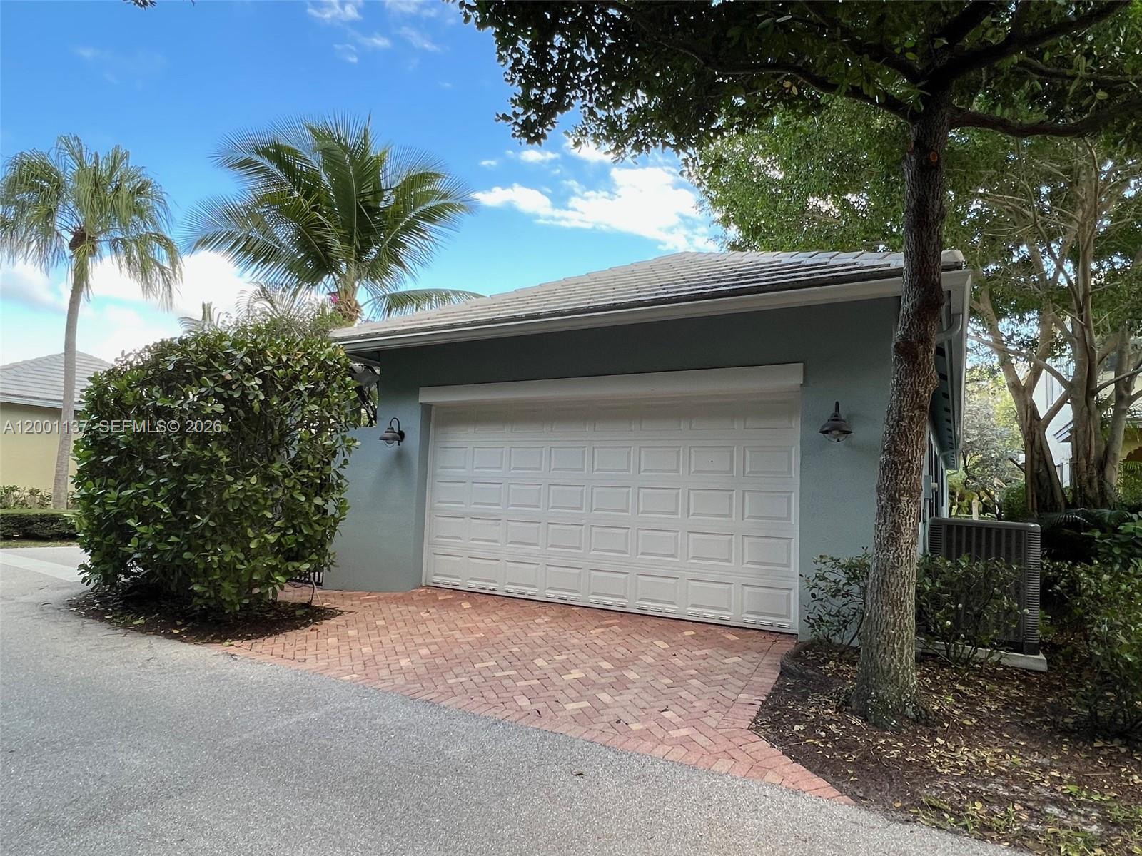184 West Bay Cedar Circle Jupiter, FL 33458 - Photo 36 of 49 a house with a yard and garage