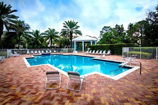 184 West Bay Cedar Circle Jupiter, FL 33458 - Photo 40 of 49 a view of a swimming pool with chairs in patio