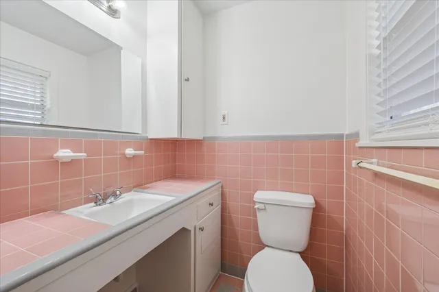 a bathroom with a toilet sink and mirror