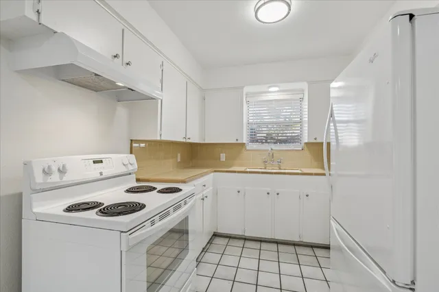a kitchen with a sink a stove and cabinets