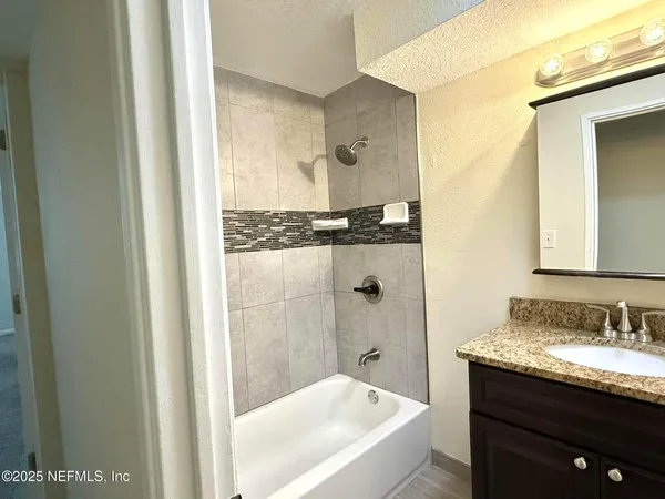 a bathroom with a granite countertop sink and a mirror