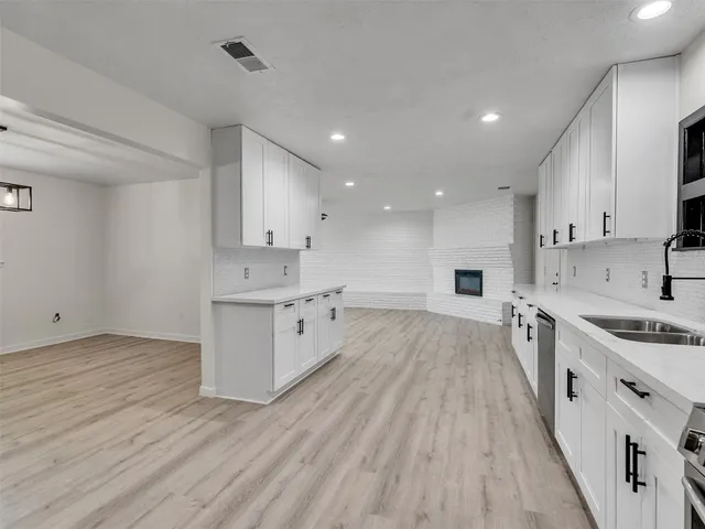 a large kitchen with stainless steel appliances granite countertop a large stove a sink dishwasher and a refrigerator with wooden floor